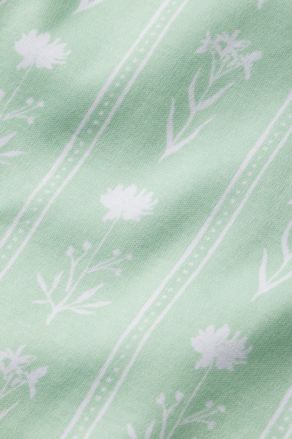 The Pima Short Robe in Parisian Green Watercolor Stems features a delicate pattern of white floral silhouettes and thin vertical lines on Pima cotton, creating an elegant look with various flowers and stems.