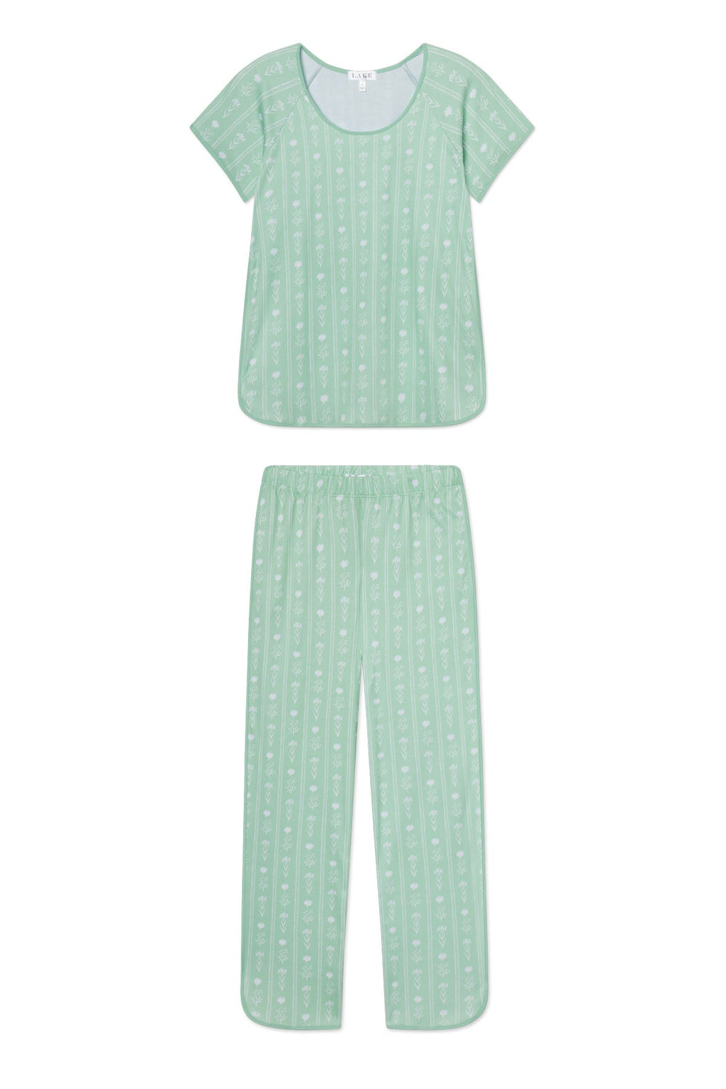 The Pima Short-Long Set in Parisian Green Watercolor Stems is a light green pajama ensemble with a short-sleeve top and long pants, crafted from soft Pima cotton. It showcases delicate white floral motifs and a subtle striped pattern.